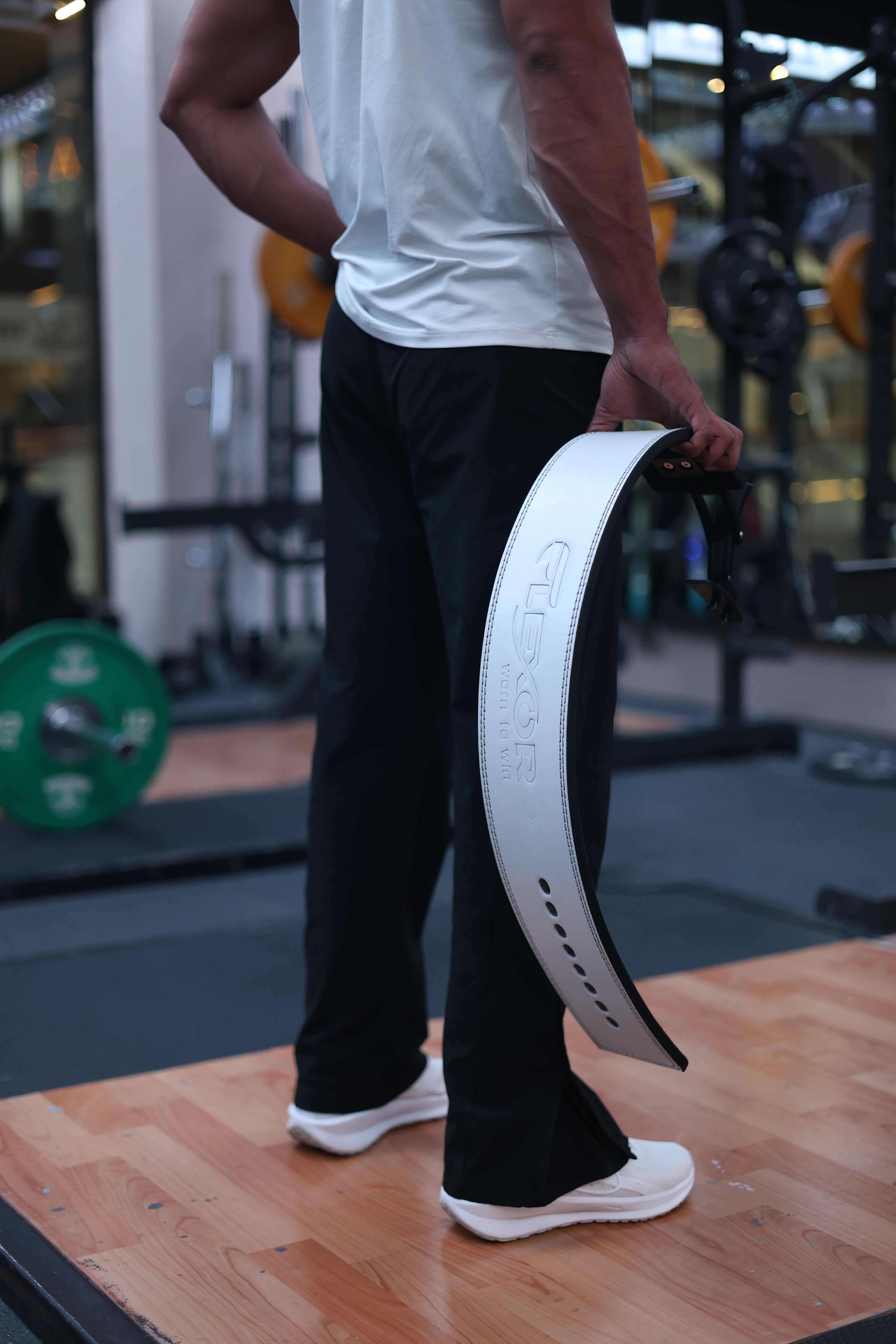 Athlete holding a premium white lever belt, showcasing 10 mm powerlifting lever belts in India and durable gym belts India.